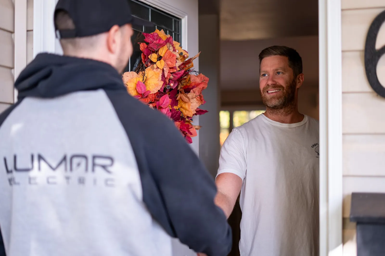 A LuMar Electric electrician greeting a homeowner at the front door